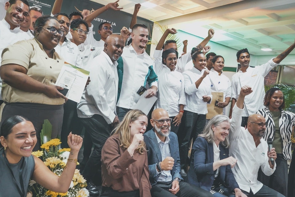Group of chefs cheering with hands waving at the Australian stand at the Taste of Australia Event.