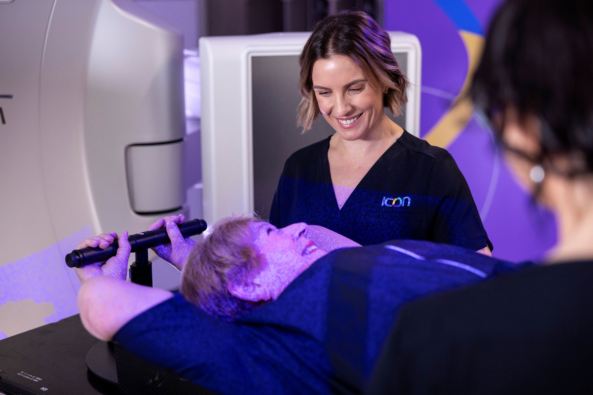 A woman lying down on a medical scanning table as part of scanning for cancer