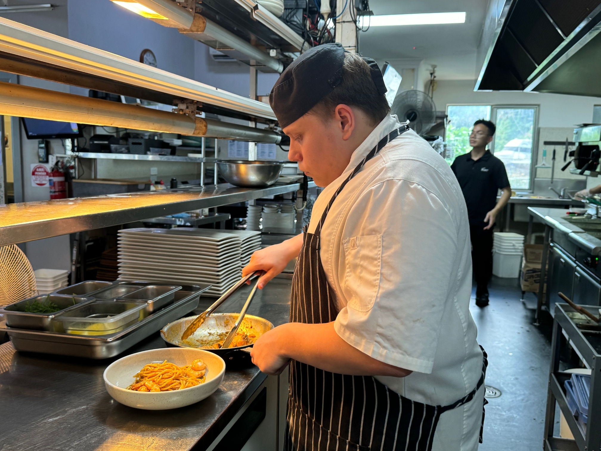 A man in a chef's apron cooking in a kitchen.