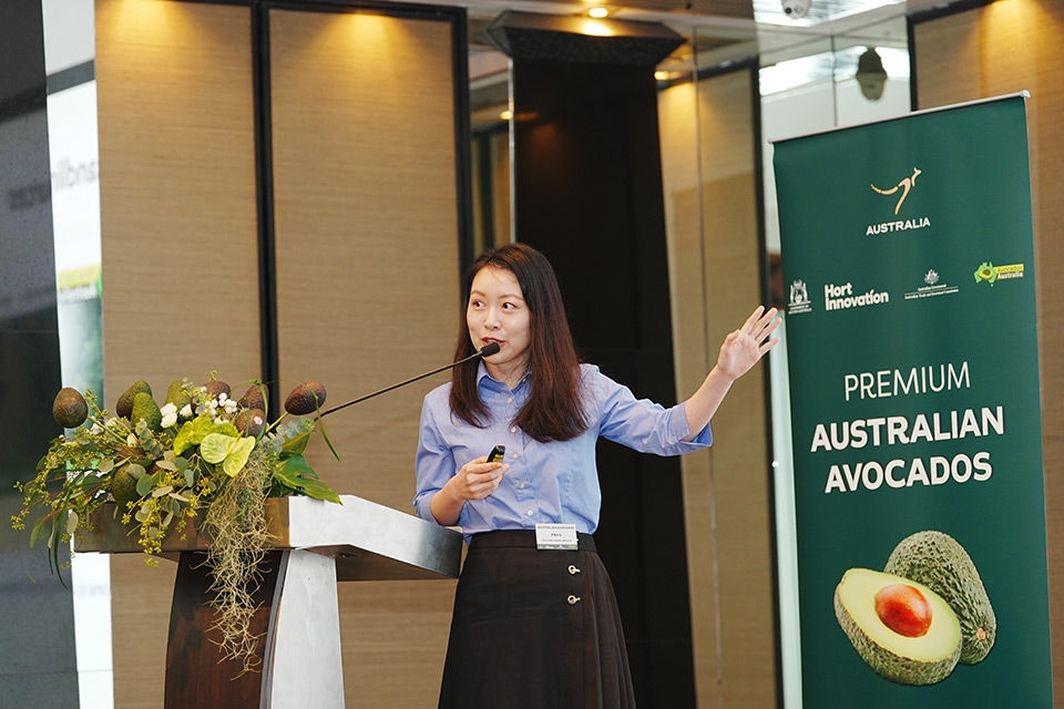 Flora standing at the podium at the Avo launch in Bangkok 2023.