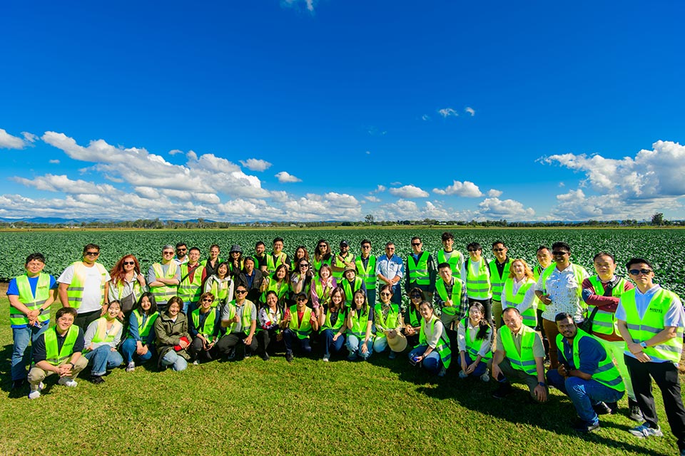 Delegates from 12 countries in a field as part of 2025 Reverse Trade Mission. Image courtesy of AUSVEG.