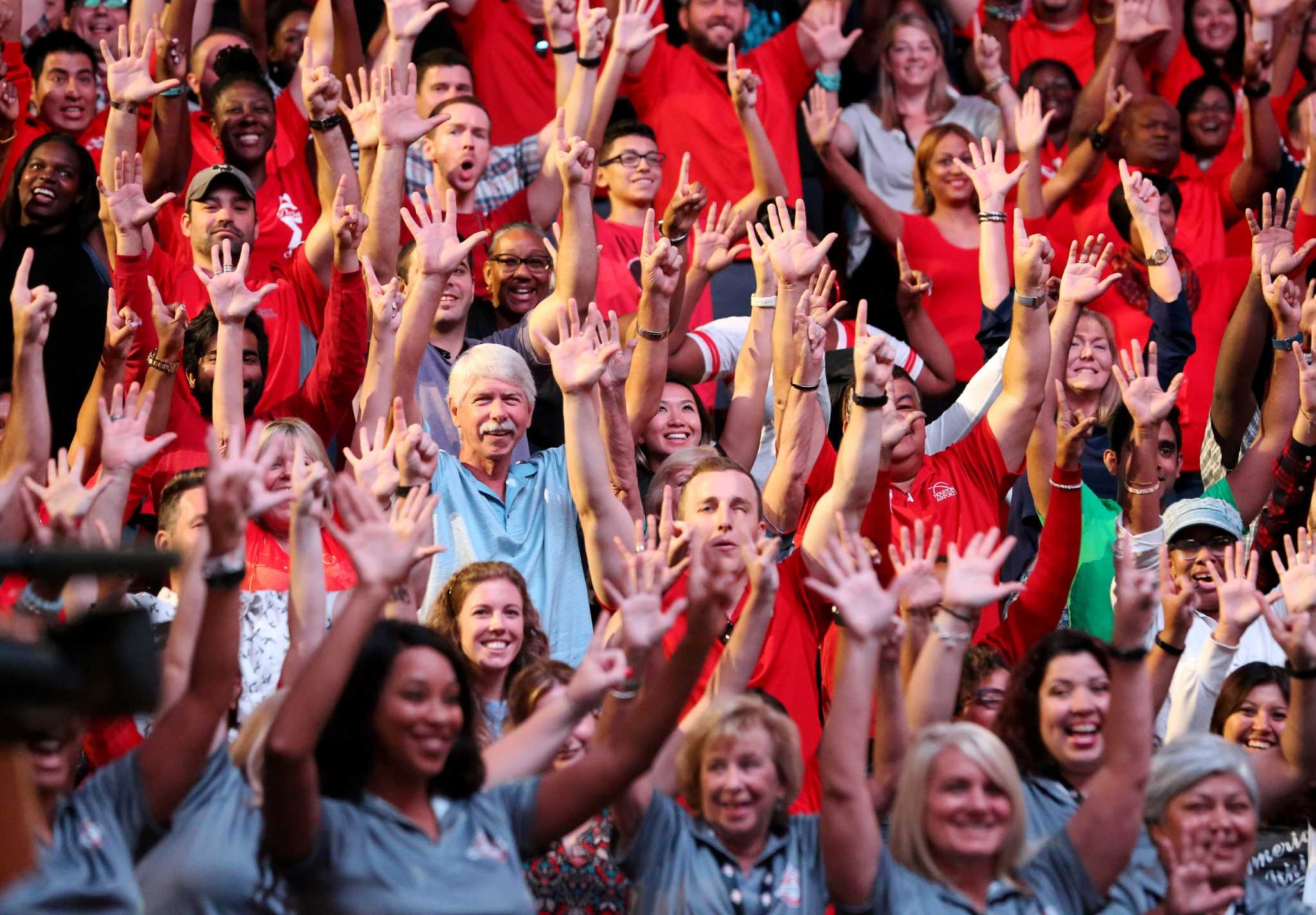 Crowd of Rosterfy volunteers, smiling with their hands in the air.