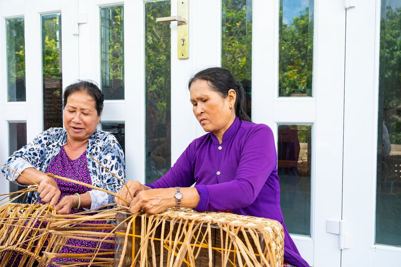 Vietnamese weavers creating a work out of bulrush.