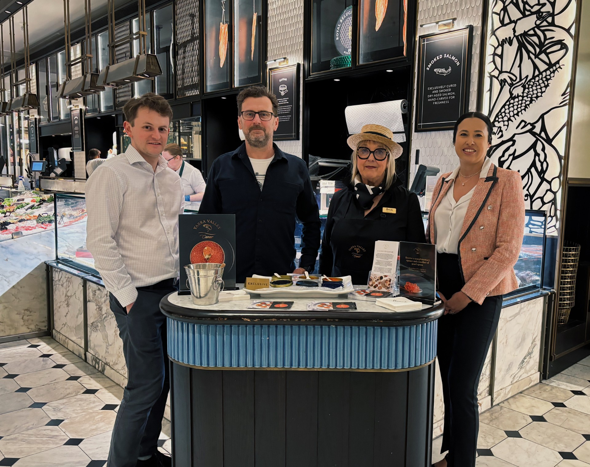 A group of two men and two women standing at a podium. displaying a range of Yarra Valley Caviar products.