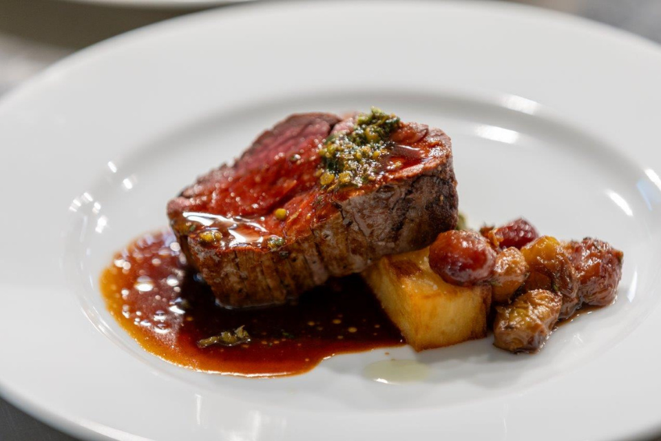 Slice of steak, garnished and served with potatoes